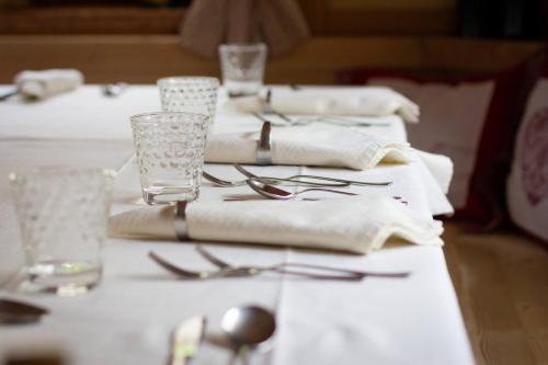 a table with white napkins and silverware on it at Hotel & Ristorante Baita Dovich in Malga Ciapela
