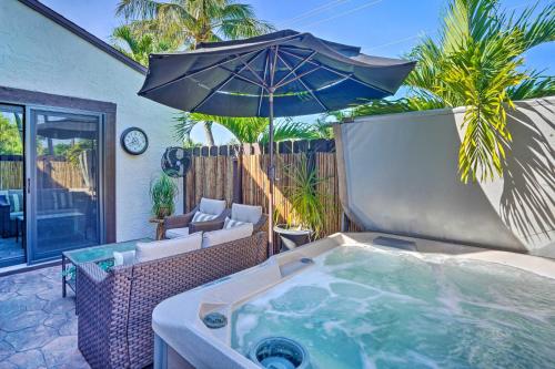an outdoor hot tub with an umbrella on a patio at Chic Fort Myers Escape with Community Perks! in Fort Myers