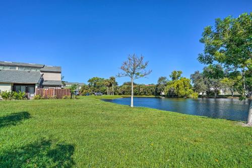 a tree in the grass next to a river at Chic Fort Myers Escape with Community Perks! in Fort Myers
