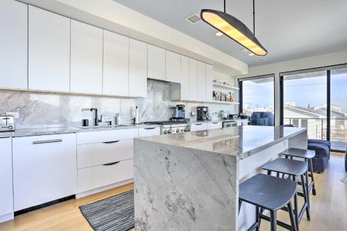 a kitchen with white cabinets and a counter with stools at Luxury Long Beach Villa with Ocean Views! in Long Beach
