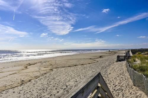a sandy beach with a fence and the ocean at Luxury Long Beach Villa with Ocean Views! in Long Beach