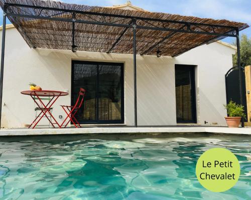 une pergola au-dessus d'une piscine en face d'une maison dans l'établissement LOGIS DES ROCHES - 2 VILLAS VUE EXCEPTIONNELLE - Le Petit Chevalet, Le Grand Sabouillon, à Buis-les-Baronnies
