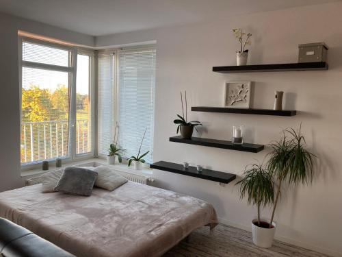 a bedroom with a bed and a window with plants at Apartment Husova in Poděbrady