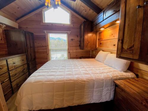 ein Schlafzimmer mit einem Bett in einer Holzhütte in der Unterkunft B1 NEW Awesome Tiny Home with AC Mountain Views Minutes to Skiing Hiking Attractions in Carroll