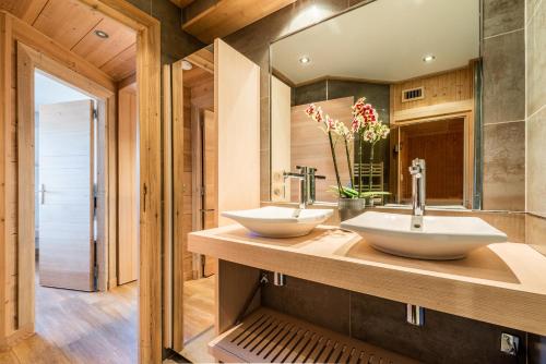 2 lavandini su un bancone in legno in bagno di Apartment Itauba Courchevel 1850 - by EMERALD STAY a Courchevel