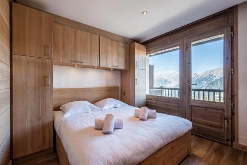 una camera da letto con un letto con due cuscini sopra di Apartment Itauba Courchevel 1850 - by EMERALD STAY a Courchevel