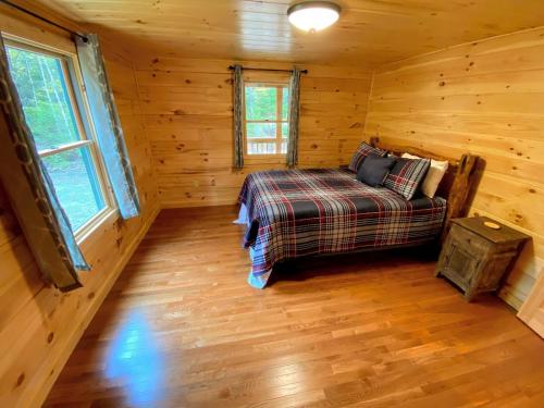 a bedroom with a bed in a log cabin at Brand New Log Home Well appointed great location with AC wifi cable fireplace firepit in Bethlehem