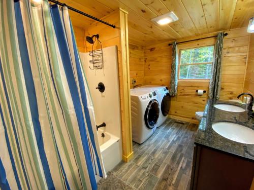 a bathroom with a washing machine and a washer and dryer at Brand New Log Home Well appointed great location with AC wifi cable fireplace firepit in Bethlehem