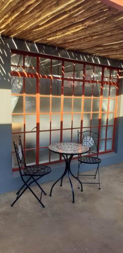 a table and two chairs in a room at At Rest in Zeerust