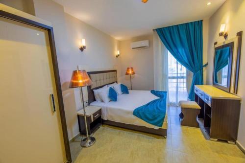 a bedroom with a bed with blue sheets and a mirror at One Bedroom Suite with Aqua View at Mirage Bay Resort in Hurghada