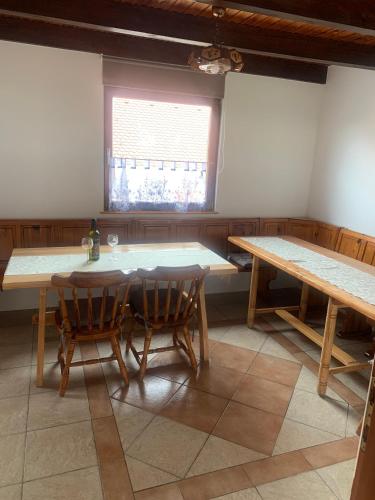 a dining room with two tables and a window at Apartma med vinogradi in Ljutomer