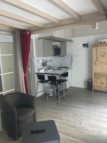 une pièce avec une cuisine avec une table et des chaises dans l'établissement Chaleureux studio familal 