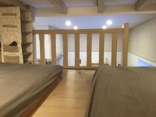 - une chambre avec 2 lits et un escalier dans l'établissement Chaleureux studio familal 