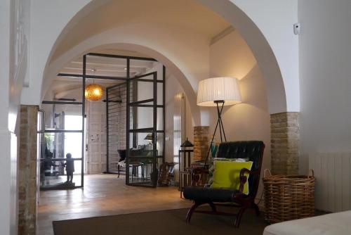 a living room with an archway with a chair and a lamp at La Casita del Mar in Sitges