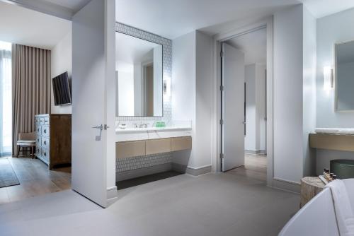 a bathroom with a sink and a mirror at La Colombe d'Or Hotel in Houston