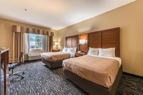 a hotel room with two beds and a window at Quality Inn & Suites Hendersonville - Flat Rock in Flat Rock