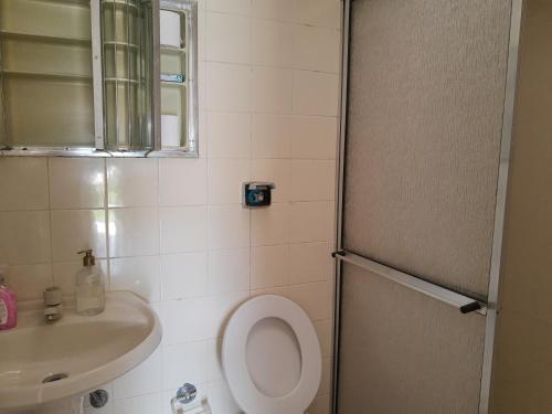 La petite salle de bains est pourvue de toilettes et d'un lavabo. dans l'établissement Assahi, à Valinhos