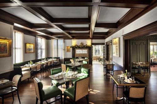 a dining room with tables and green chairs at La Colombe d'Or Hotel in Houston