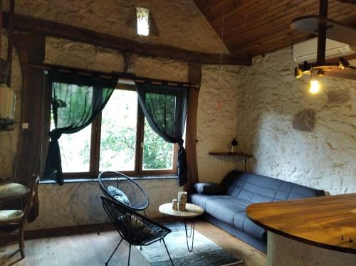 ein Wohnzimmer mit einem blauen Sofa und einem Tisch in der Unterkunft grange rénovée en pleine nature in Valady