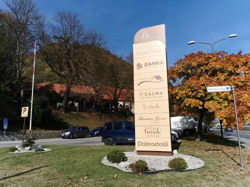 a tall sign in the grass next to a street at Apartment Belaj in Celje