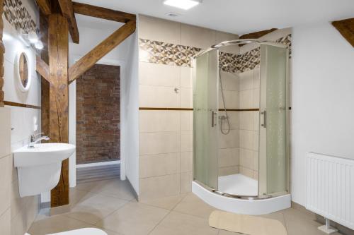 uma casa de banho com um chuveiro e um lavatório. em Kawerna Obornicka Pod Orłem Noclegi em Oborniki