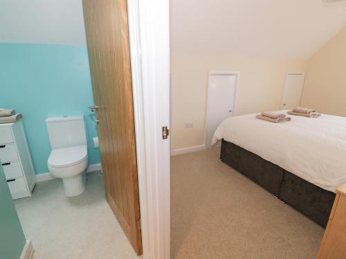 a bathroom with a bed and a toilet in a room at Rose Cottage in Stratford-upon-Avon