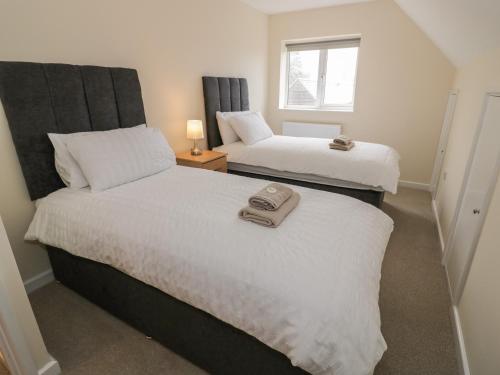 2 camas en una habitación pequeña con ventana en Rose Cottage, en Stratford-upon-Avon