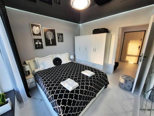 a bedroom with a black and white bed in it at Apartament 10 Glamour Aquapark Reda in Reda