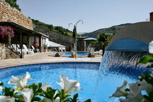 a swimming pool with a water feature in a resort at Alojamientos Rurales Benarum con Spa in Alpujarra De La Sierra
