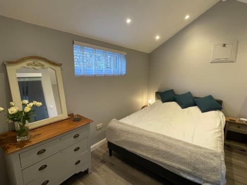 een slaapkamer met een bed, een dressoir en een spiegel bij Beautiful self-catering cottages, Ribble Valley in West Bradford