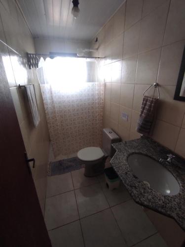 ein kleines Bad mit einem Waschbecken und einem WC in der Unterkunft Pousada Laguna Beach Club in São Pedro da Aldeia