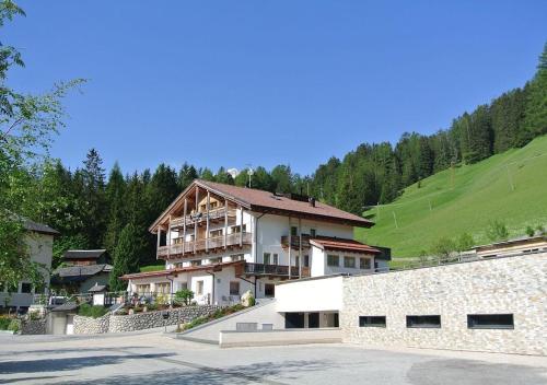 a large building in the middle of a mountain at Apartments & Garnì Pre Da Nai in La Villa