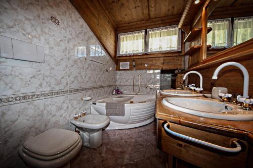 a bathroom with a toilet and a sink and a tub at Appartamento Mainardi in Auronzo di Cadore