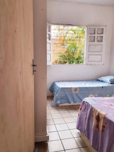 a room with two beds and a window at Home in Family in Maceió