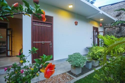 a front door of a house with flowers and plants at Saku Residence in Unawatuna