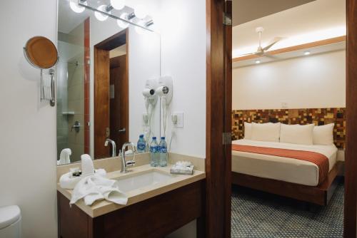 Habitación de hotel con cama y lavabo en Rouge By La Gran Francia, en Granada