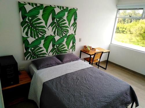 ein Schlafzimmer mit einem Bett und einem großen Fenster in der Unterkunft Hotel La Aldea del Oriente in Marinilla