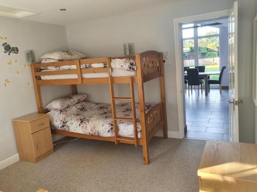 Zimmer mit 2 Etagenbetten und einem Esszimmer in der Unterkunft willow tree farm cottage with BBQ hut in Tattershall Thorpe