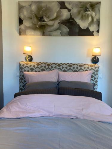 a bedroom with a bed with a painting on the wall at Le Galet de Cassis by K6&you in Cassis