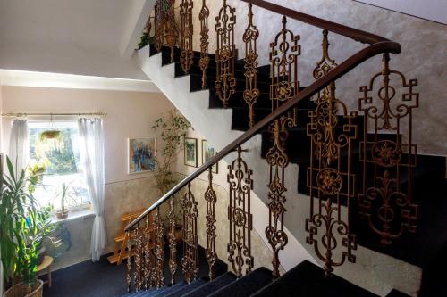 a staircase in a home with a wrought iron railing at Hotel Atlas in České Budějovice