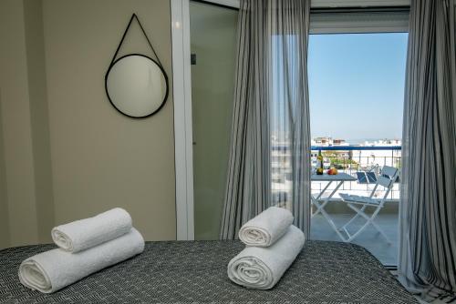 a bedroom with towels on a bed with a balcony at Miracle Luxury Apartments in Perea