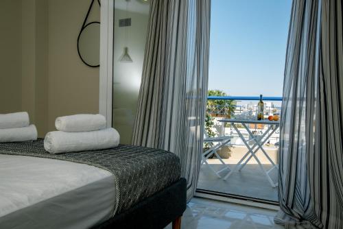 a bedroom with a bed and a balcony with a view at Miracle Luxury Apartments in Perea