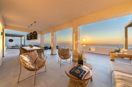 een woonkamer met uitzicht op de oceaan bij Eolia Luxury Villas in Pirgos