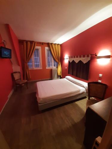 una camera rossa con un letto e due sedie di Hotel du Cygne a Beauvais
