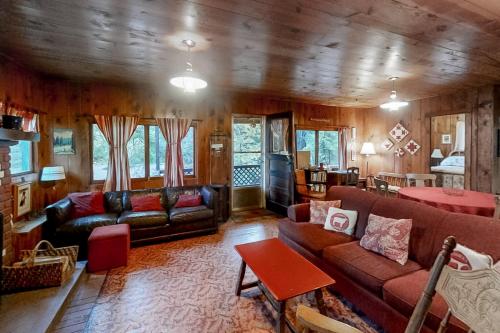 uma sala de estar com sofás de couro e uma mesa em Pine Cone Cottage em Joseph