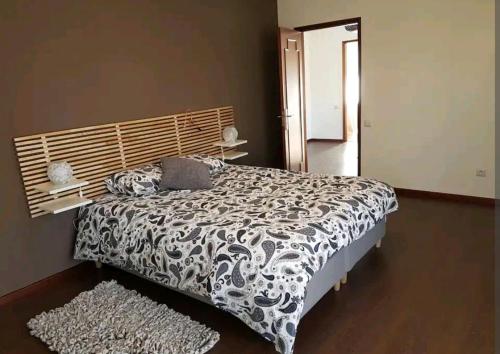 a bedroom with a bed with a black and white comforter at Vivenda junto ao mar in Mindelo