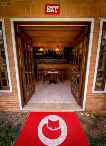 a red carpet with a cat on it in a building at Pousada O Cantinho da Raposa in Monte Verde