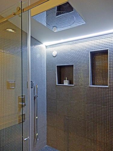 une salle de bain avec douche aux carreaux bleus dans l'établissement Chateau La Mothe du Barry, à Moulon-sur-Dordogne