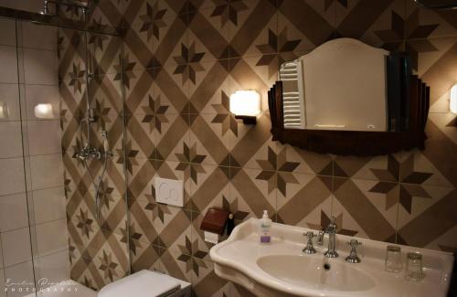 a bathroom with a sink and a toilet and a mirror at La Villa du Pré Du Cerf in Spa