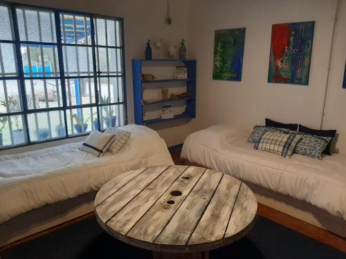 Habitación con 2 camas y mesa de madera. en Casa de Campo La Magdalena en Tunuyán